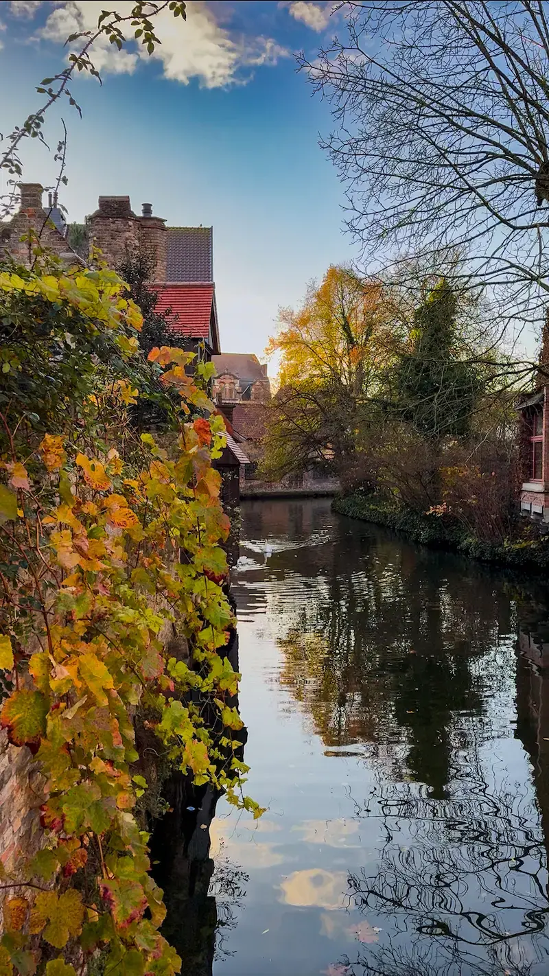 A stone bridge over a canal in Bruges with historic houses
